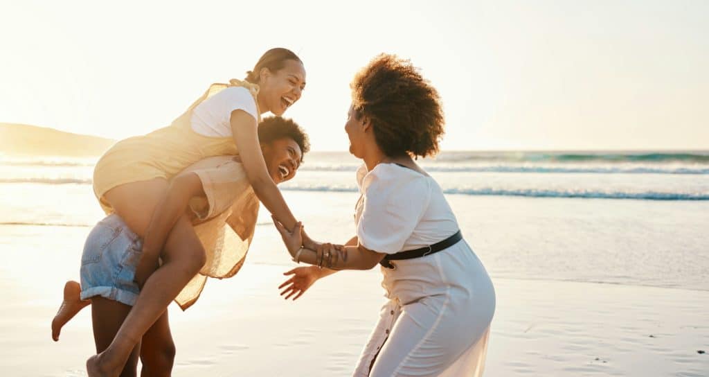 Beach sunset, happy women and friends piggyback, smile and enjoy travel vacation, adventure and sum